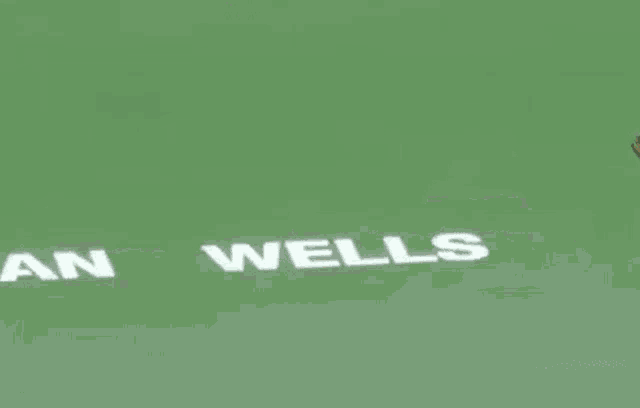 a man is running on a tennis court with the words indian wells on the ground