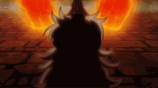 a silhouette of a person with a fire behind them