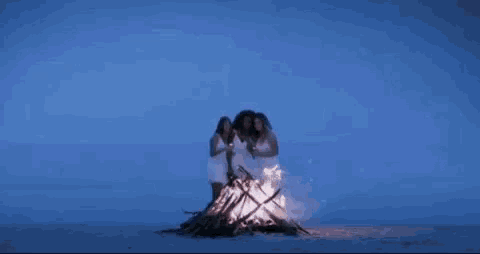 three women are standing next to each other holding candles