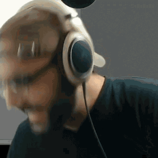 a man with a beard is wearing headphones and a green shirt .