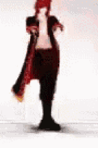 a person in a red coat and black pants is standing on a white surface .
