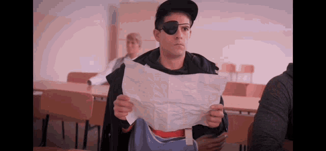 a man wearing a pirate eye patch is holding a piece of paper .