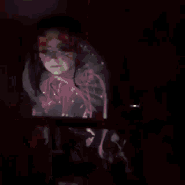 a blurry picture of a person 's hand holding a red object