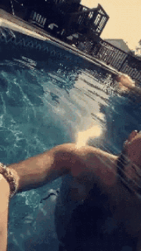 a person is laying in a swimming pool with their arms outstretched