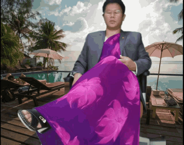a man in a suit and a purple dress is sitting in a chair