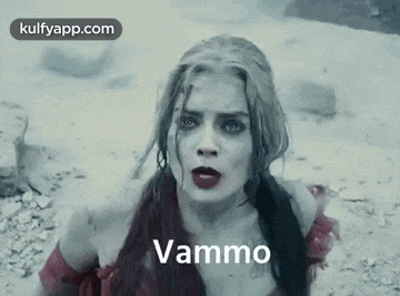 a woman in a red dress is laying in the dirt with the words vammo written on her face .