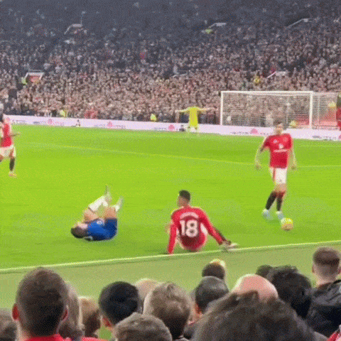 a soccer player with the number 18 on his jersey is sitting on the ground