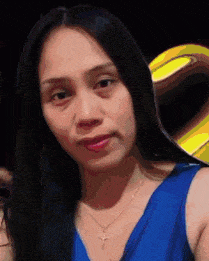 a woman wearing a blue tank top and a gold cross necklace