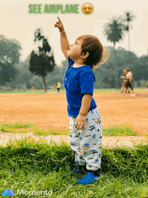 a baby is pointing up with the words see airplane behind him