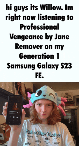 a girl in a fish or new monster shirt is holding a cellphone
