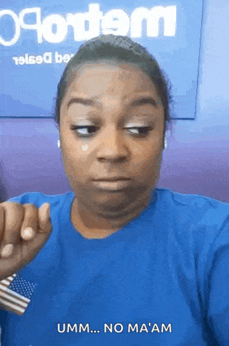 a woman in a blue shirt is making a face and says umm no ma am