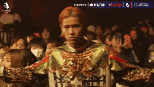 a man with red hair is standing in front of a crowd with the number 30 written on the bottom