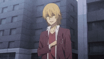 a man with blonde hair and a red shirt is standing in front of a building .