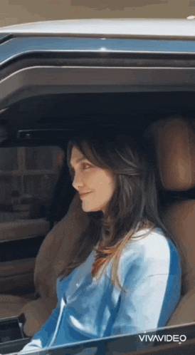 a woman is sitting in the driver 's seat of a car with vivavideo written on the bottom