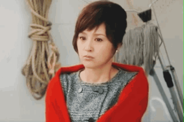 a woman with a red scarf around her neck looks at the camera