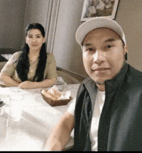a man and a woman are sitting at a table with a basket of bread