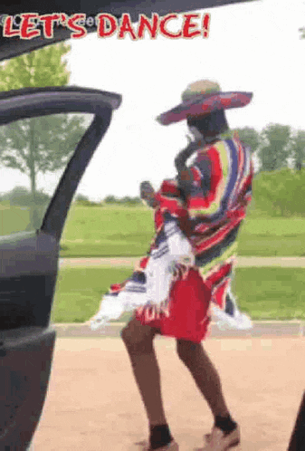 a man in a sombrero and a poncho is dancing in the back of a car .