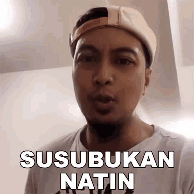a man wearing a hat says susubukan natin in a white shirt