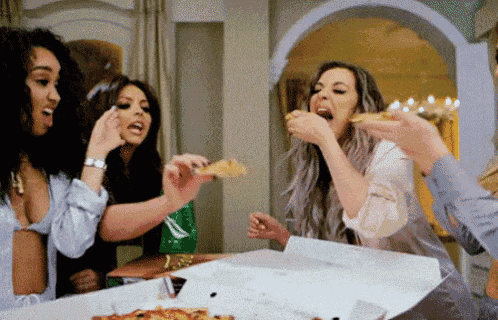 a group of women are eating pizza from a pizza box .