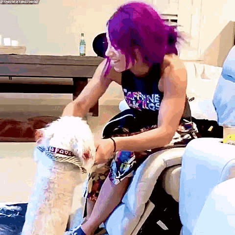 a woman with purple hair is playing with a white dog