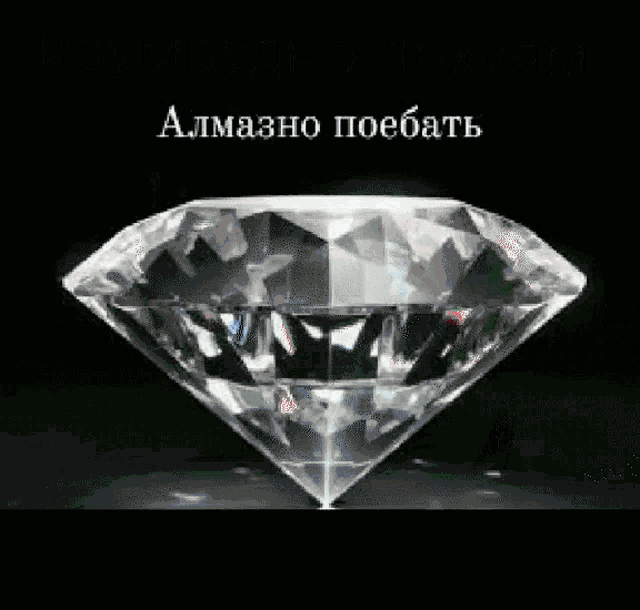 a large diamond is sitting on a black surface with russian writing on it .