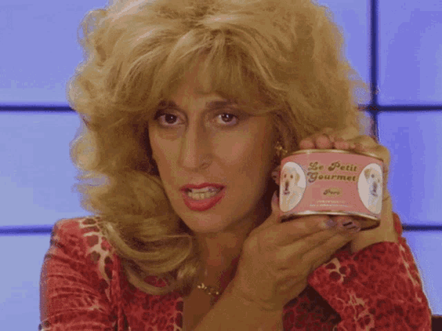 a woman is holding a can of le petit gourmet dog food