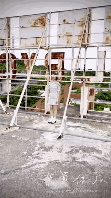 a woman in a blue dress is standing on a rooftop with chinese writing