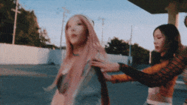 two women with pink hair are standing next to each other