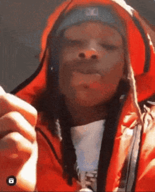 a close up of a person wearing a red jacket and a blue hat .