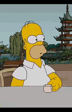 a cartoon of homer simpson sitting at a table