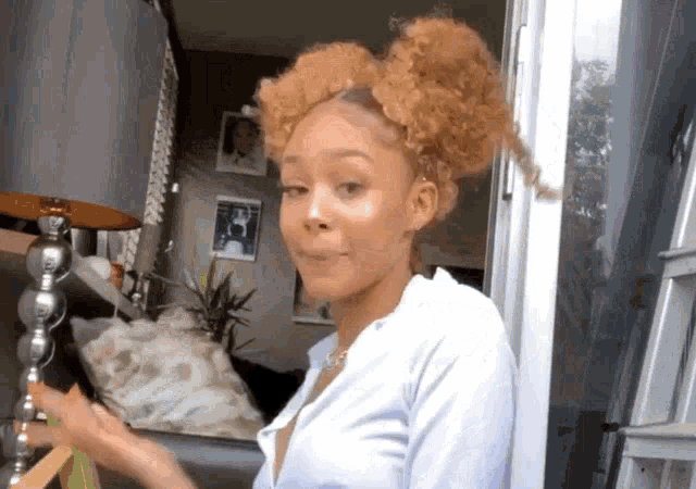 a woman with curly hair is standing in front of a glass door