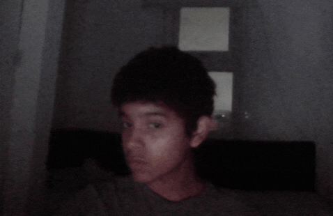 a young boy is taking a picture of himself in a dark room