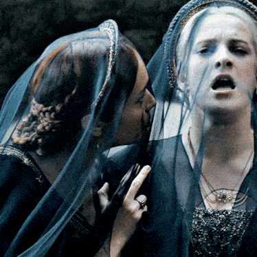 a woman with a veil on her head is kissing another woman on the cheek