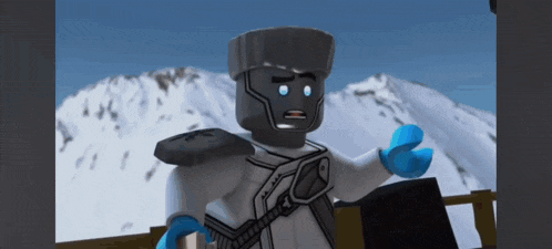 a lego figure is standing in front of a snow covered mountain .