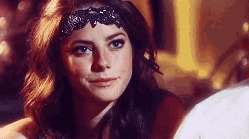 a close up of a woman wearing a black headband .