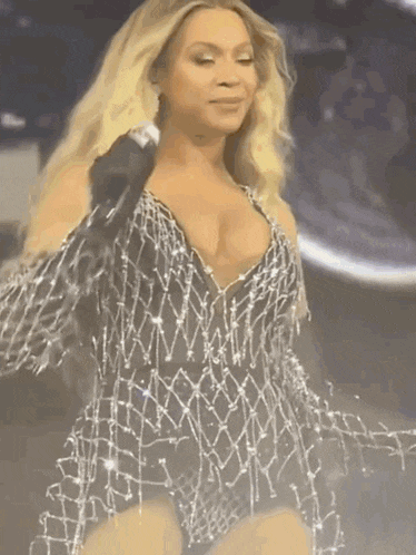 a woman in a very revealing outfit is singing into a microphone .