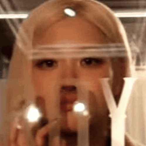 a close up of a woman 's face behind a clear glass .