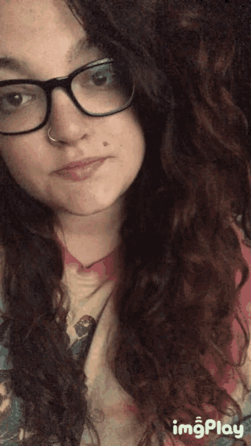 a close up of a woman wearing glasses and a pink shirt with imgplay written on the bottom