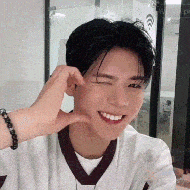 a young man with a bracelet on his wrist is smiling and making a face