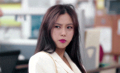 a close up of a woman wearing a white jacket and purse .