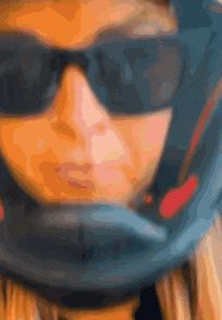 a close up of a person wearing sunglasses and a blue helmet