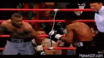 two men are fighting in a boxing ring .