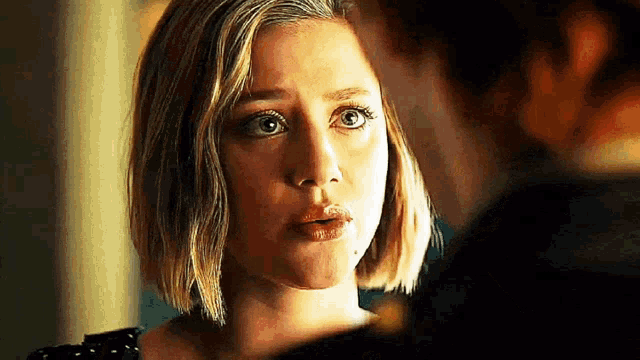 a close up of a woman 's face looking at a man 's face .