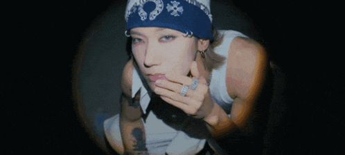 a woman wearing a blue bandana and a ring on her finger