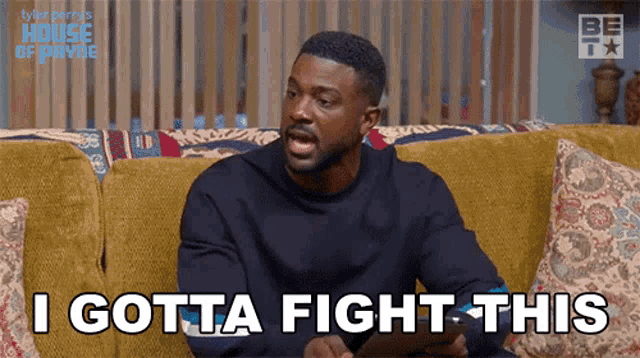 a man is sitting on a couch and says i gotta fight this