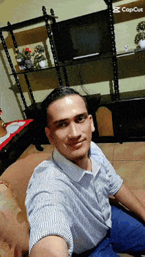 a man is taking a selfie in front of a tv with capcut in the corner