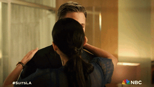 a man and woman hugging with a nbc logo in the background