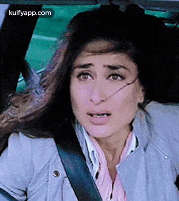 a woman is sitting in the back seat of a car with a seat belt on .