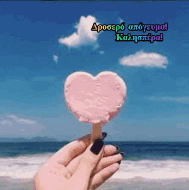 a person is holding an ice cream in the shape of a heart on a stick .