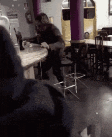 a man sits at a table in a restaurant with tables and chairs